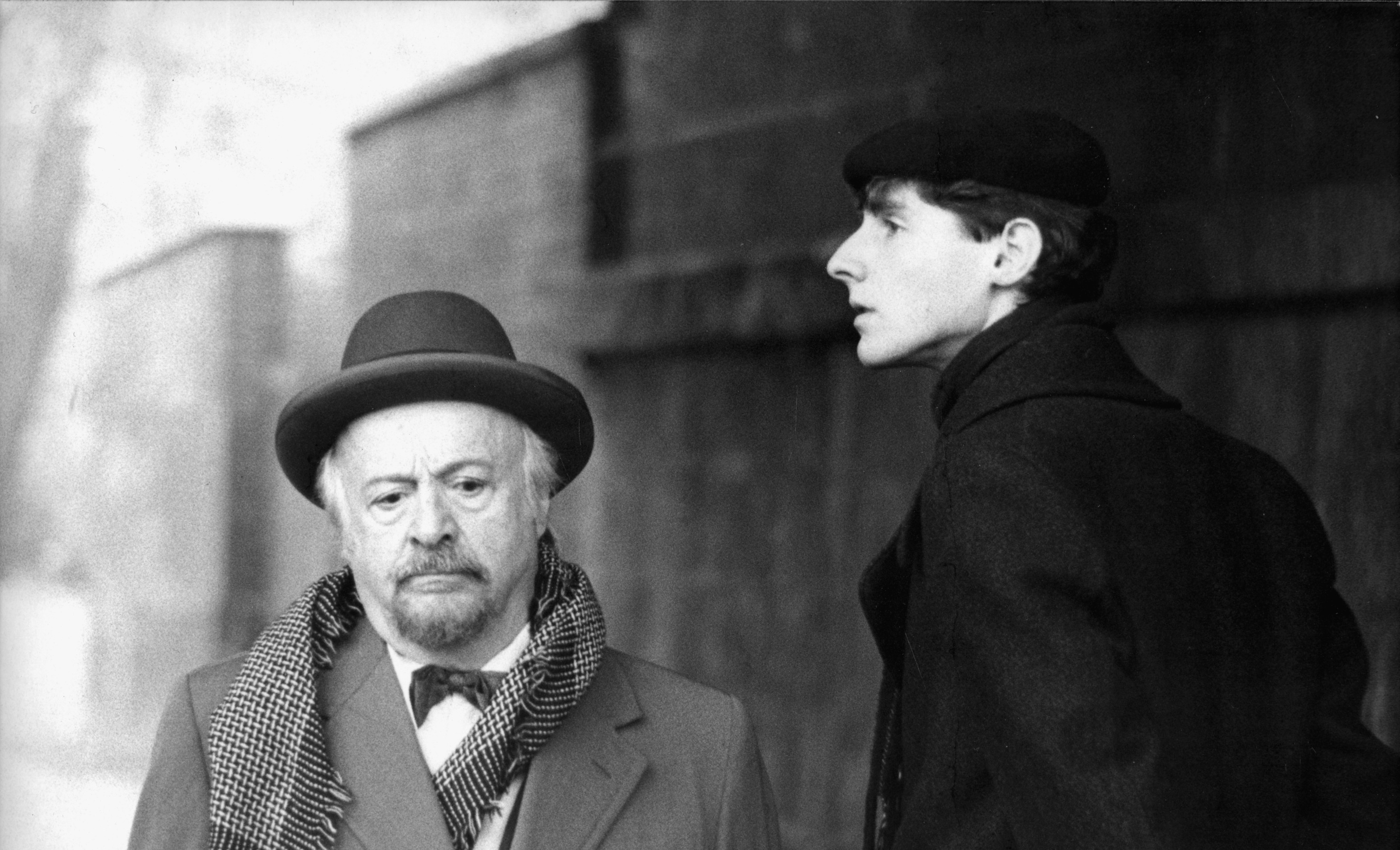 KI generiert: Das Bild zeigt zwei Männer in einem ernsten Moment, einer trägt einen Mantel mit einem Judenstern. Die Szene stammt aus dem Film "David", der von Peter Lilienthal inszeniert wurde.