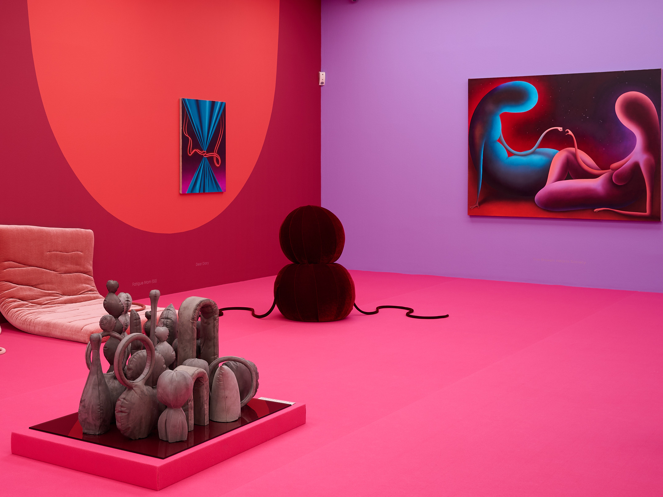 KI generiert: Das Bild zeigt einen farbenfrohen Ausstellungsraum mit moderner Kunst, unter anderem Skulpturen und Gemälde. Die dominierenden Farben sind kräftige Pink-, Rot- und Lilatöne, die eine lebendige Atmosphäre schaffen.