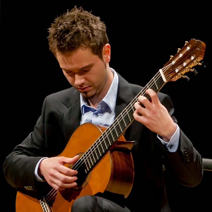 KI generiert: Ein Mann in einem Anzug spielt eine klassische Gitarre. Sein Fokus liegt intensiv auf dem Instrument.