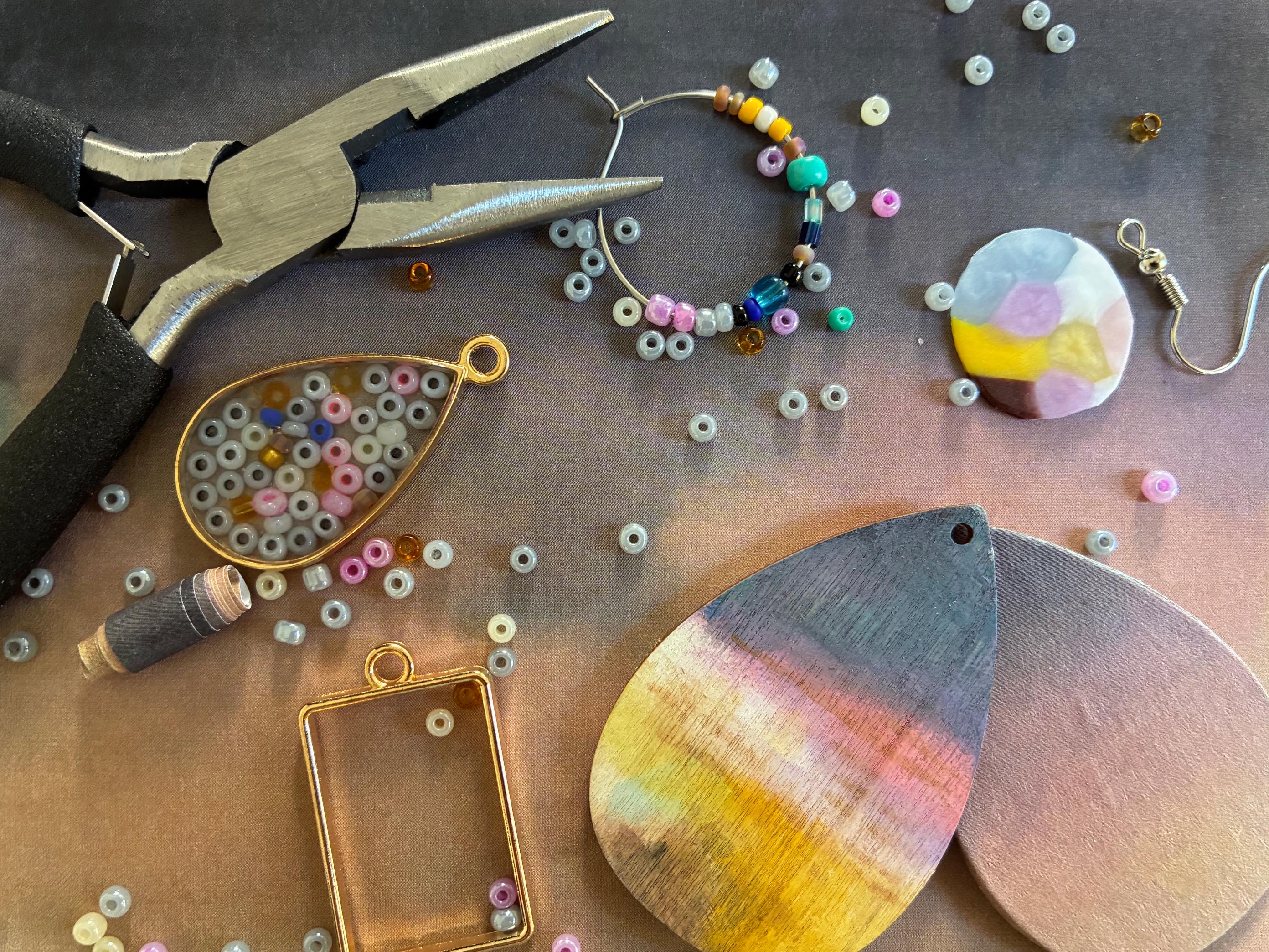 KI generiert: Das Bild zeigt Werkzeuge und Materialien zur Schmuckherstellung, darunter Zangen, Perlen und Anhänger. Der Fokus liegt auf der kreativen Gestaltung von Schmuckstücken.