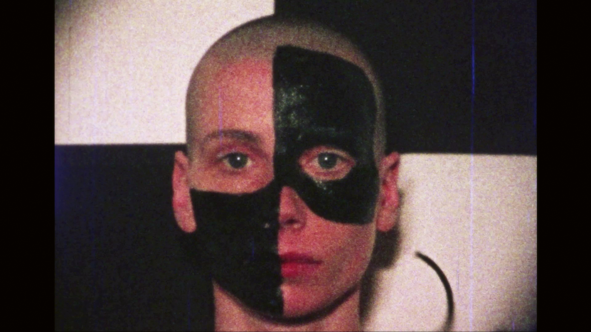 KI generiert: Das Bild zeigt eine Person mit kahl rasiertem Kopf, deren Gesicht zur Hälfte schwarz bemalt ist. Der Hintergrund besteht aus einem schachbrettartigen Muster.